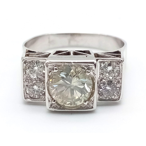 274 - An 18 K white gold ring with a large (1.85 carats) brilliant cut diamond surrounded by four brillian... 