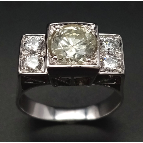 274 - An 18 K white gold ring with a large (1.85 carats) brilliant cut diamond surrounded by four brillian... 