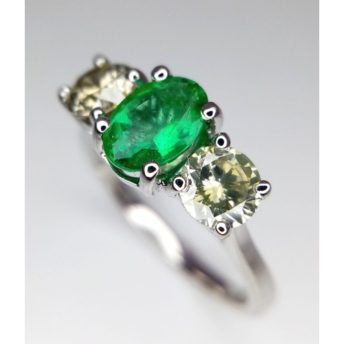 39 - A WGI certified 18K white gold emerald and diamond trilogy ring. Oval mixed cut natural emerald and ... 