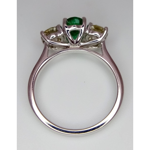 39 - A WGI certified 18K white gold emerald and diamond trilogy ring. Oval mixed cut natural emerald and ... 