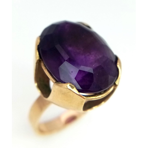 368 - A 9K GOLD DRESS RING WITH A CLAW SET AMETHYST CENTRE STONE .   7.7gms   size O