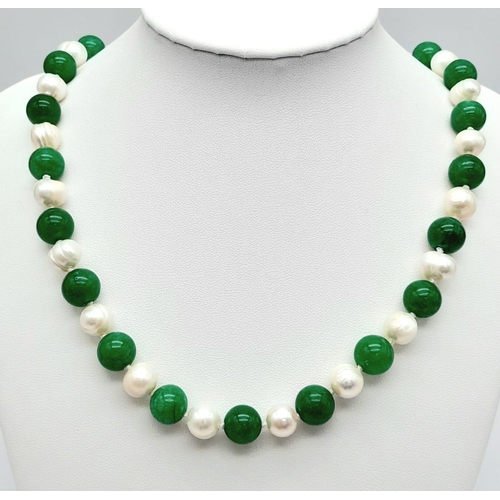 325 - A Green Jade and Cultured Pearl Necklace. 10mm jade beads with 8/9mm cultured pearls. Gilded clasp. ... 