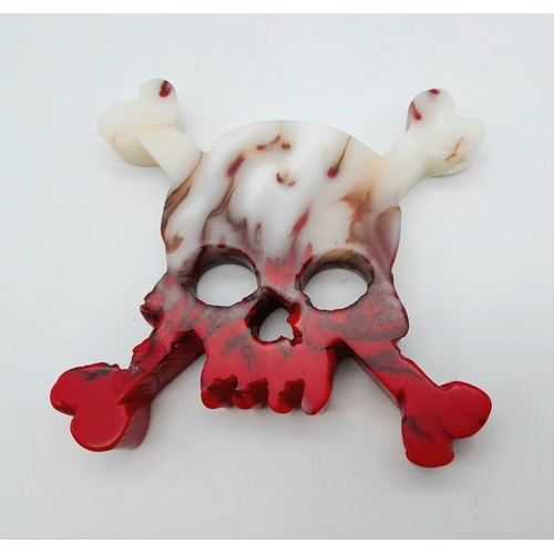 340 - A Flame Agate Hand-Carved Skull and Crossbone Ornament or Paperweight. 8.5cm x 8.5cm.