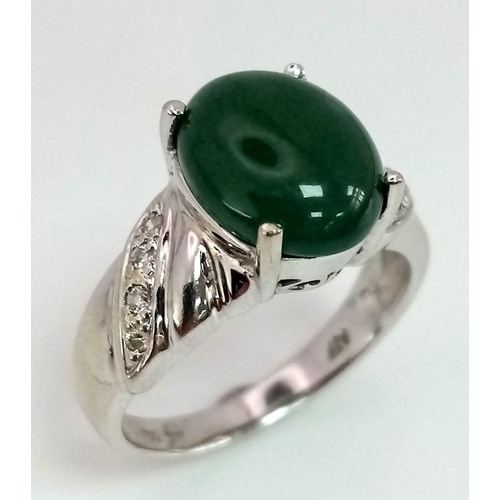 121 - 18K WHITE GOLD JADE & DIAMOND RING, WITH LOVELY JADE CABOCHON CENTRE AND DIAMONDS DECORATING ON SHOU... 