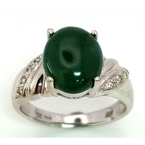 121 - 18K WHITE GOLD JADE & DIAMOND RING, WITH LOVELY JADE CABOCHON CENTRE AND DIAMONDS DECORATING ON SHOU... 