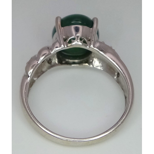 121 - 18K WHITE GOLD JADE & DIAMOND RING, WITH LOVELY JADE CABOCHON CENTRE AND DIAMONDS DECORATING ON SHOU... 