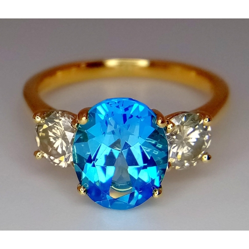 270 - A WGI certificated 18K yellow gold ring set with an oval-cut, eye-clean topaz - flanked by round bri... 