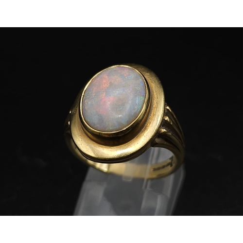 493 - AN 18K GOLD CORINTHIAN RING WITH OPAL CENTRE STONE . 7.6gms   size N/O