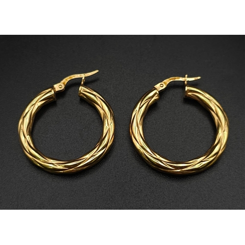 699 - A PAIR OF 9K GOLD TWIST HOOP EARRINGS .  2.15gms