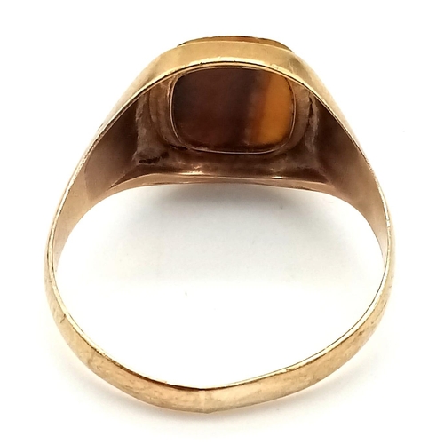 788 - A GENTS SIGNET RING WITH TIGERS EYE STONE.   3.6gms   size V