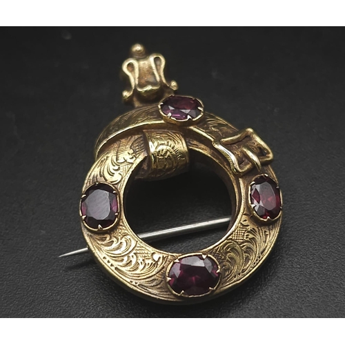 103 - An Antique Mid Karat Gold and Garnet Memorial/Union Brooch. Keeper belt design. Hair storage verso. ... 