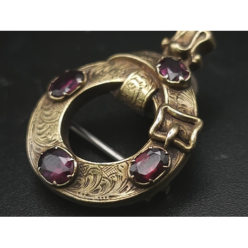 103 - An Antique Mid Karat Gold and Garnet Memorial/Union Brooch. Keeper belt design. Hair storage verso. ... 