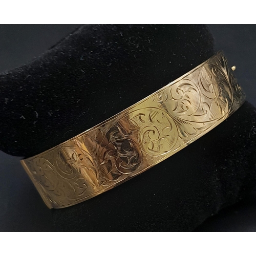 3 - A 9K GOLD NICELY DECORATED CUFF BANGLE WITH SAFETY CHAIN .    22.5gms