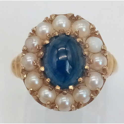 891 - A 9K GOLD RING WITH CENTRAL SAPPHIRE SURROUNDED BY SEED PEARLS .  2.9gms   size M/N