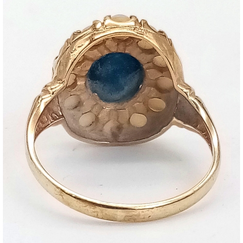 891 - A 9K GOLD RING WITH CENTRAL SAPPHIRE SURROUNDED BY SEED PEARLS .  2.9gms   size M/N