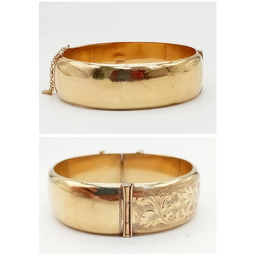 599 - A 9K GOLD HINGED BANGLE WITH SAFETY CHAIN , FLORAL DECORATION TO ONE SIDE AND SMALL DENT.  a/f    23... 