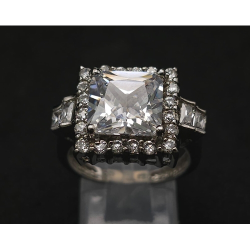 927 - A Stunning Ex Display Tier Mounted Cubic Zirconia Set Ring, Size P. 
Set with a 1cm Square Cut raise... 