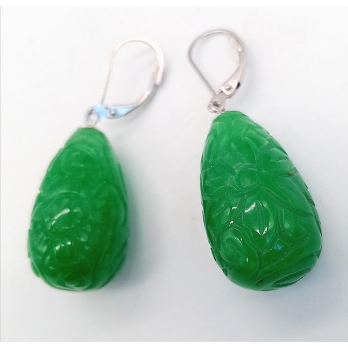 556 - A Pair of Jade Carved Teardrop Earrings. Silver clasps.