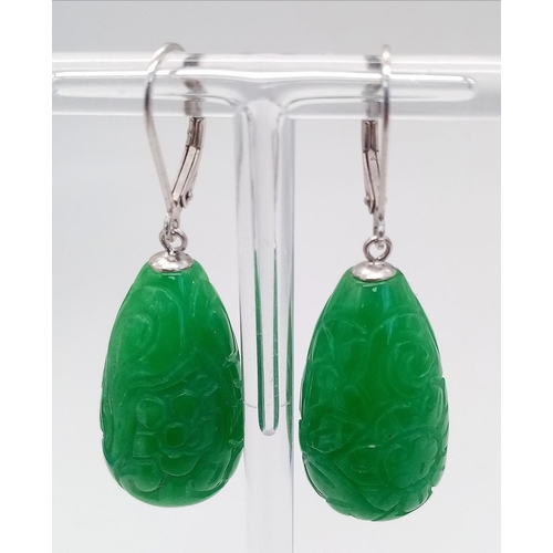 556 - A Pair of Jade Carved Teardrop Earrings. Silver clasps.