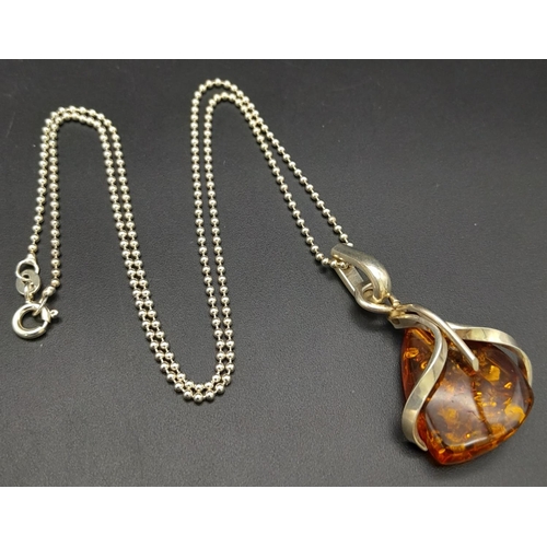 675 - A Vintage Modernist Design, Sterling Silver and Amber Set Pendant Necklace.

46cm Length, set with a... 