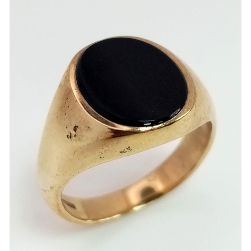 722 - A 9K Yellow Gold Onyx Signet Ring. Size N. 6.05g total weight.