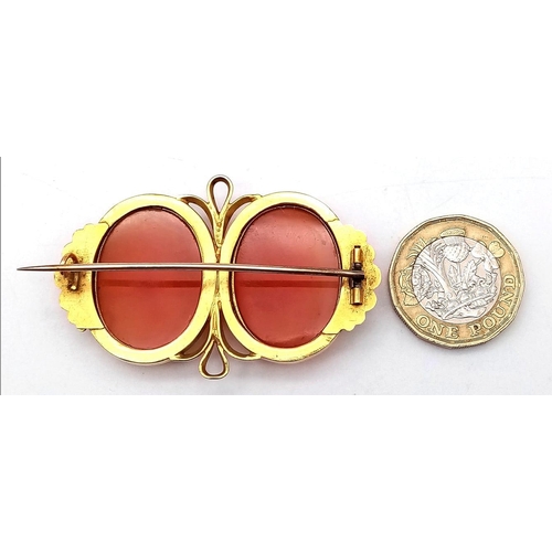 107 - An Antique 18K Yellow Gold (tested) and Carnelian Brooch. Two rich orange cabochons of carnelian set... 