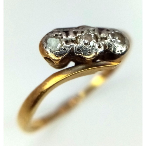 1100 - An Antique 18K Yellow Gold and Platinum Diamond Three Stone Crossover Ring. Size M. 2.13g total weig... 