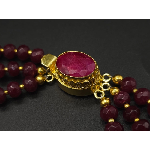 141 - A three strand necklace with multifaceted rubies and genuine pink pearls with a complimenting facete... 