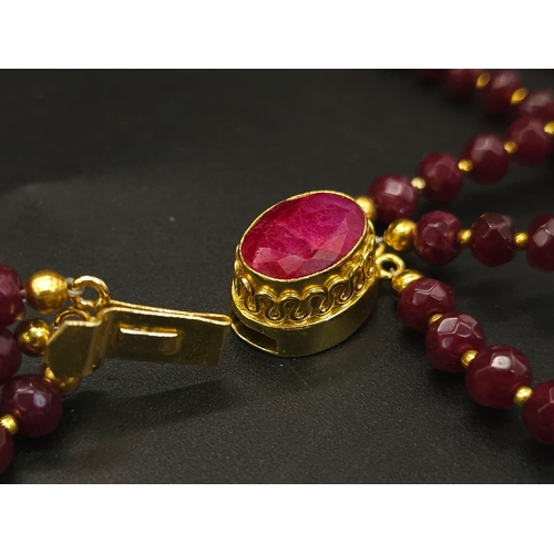 141 - A three strand necklace with multifaceted rubies and genuine pink pearls with a complimenting facete... 