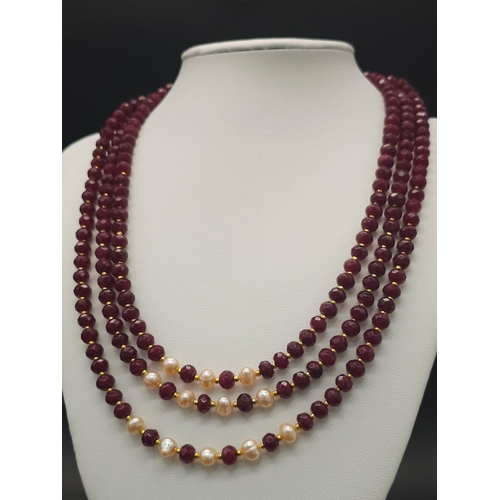 141 - A three strand necklace with multifaceted rubies and genuine pink pearls with a complimenting facete... 