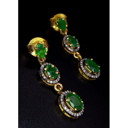 113 - An Edwardian pair of silver and gold earrings with emeralds and old cut diamonds presented in a beau... 