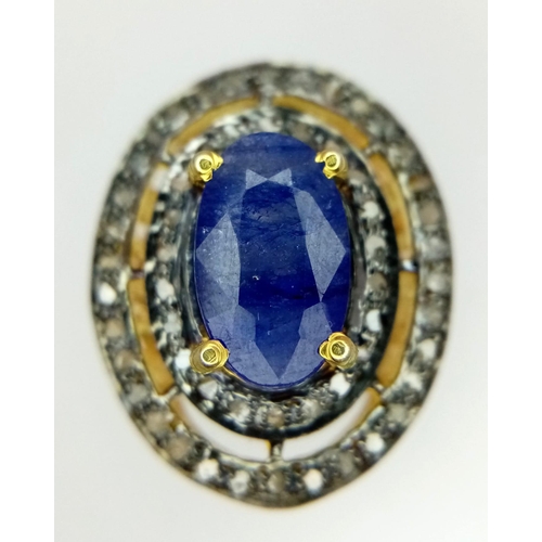 211 - An Edwardian silver and gold overlay ring with an oval cut sapphire surrounded by, not one but, two ... 