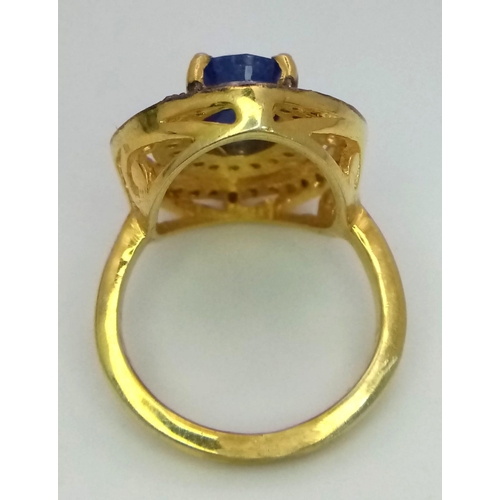 211 - An Edwardian silver and gold overlay ring with an oval cut sapphire surrounded by, not one but, two ... 