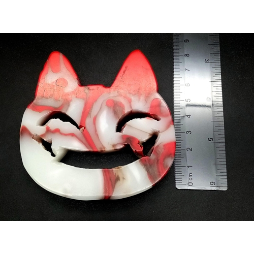 346 - A Hand-Carved Natural Flame Agate Smiling Cheshire Cat Face. Ornament or paperweight. 8cm x 8cm.