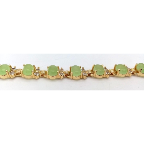 851 - A Green Jade Tennis Bracelet. Oval jade pieces set in gilded metal with white stone decoration. 19cm... 