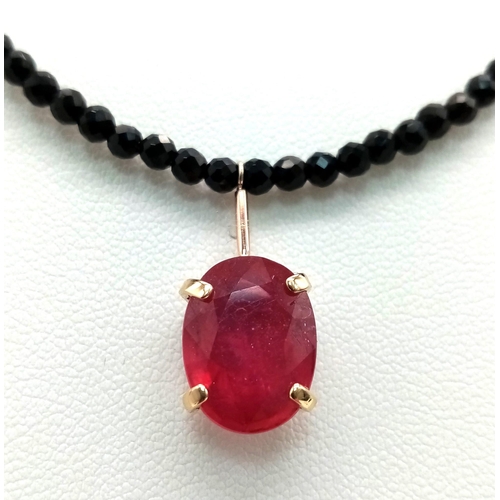 702 - A Black Spinel Small Bead Necklace with Hanging Ruby Decoration. 14k gold clasp. 38cm length