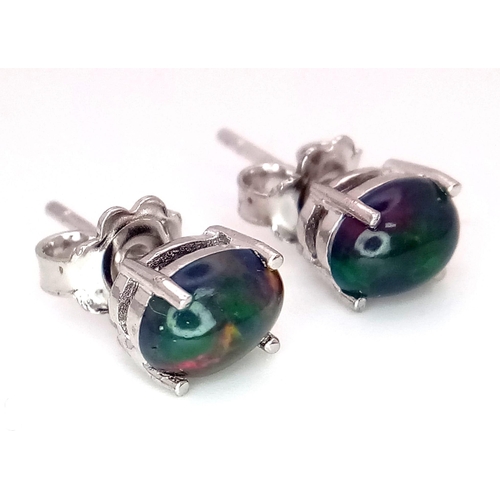 1142 - A pair of cabochon Ethiopian black opal stud earrings set in silver.