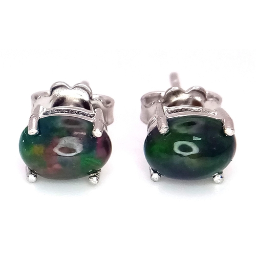 1142 - A pair of cabochon Ethiopian black opal stud earrings set in silver.