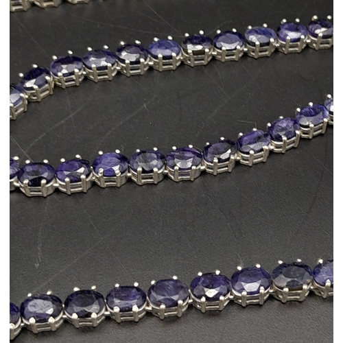 988 - A Blue Sapphire Gemstone Tennis Necklace on 925 Silver. 47.5cm in length, 38.4g total weight.