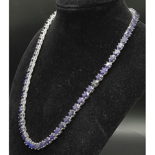 988 - A Blue Sapphire Gemstone Tennis Necklace on 925 Silver. 47.5cm in length, 38.4g total weight.