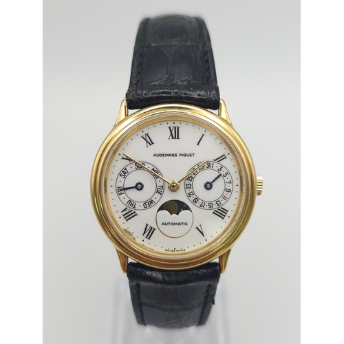 183 - An Audemars Piguet 18K Gold Automatic Moon-Phase Watch. 
Original black leather strap and 18k gold c... 