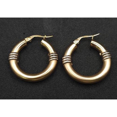 526 - A pair of 9k two-tone rounded hoop earrings. 3.6g