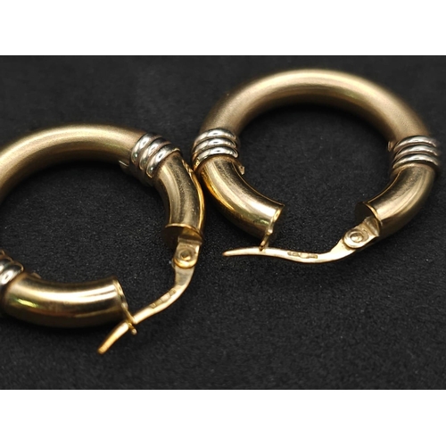 526 - A pair of 9k two-tone rounded hoop earrings. 3.6g