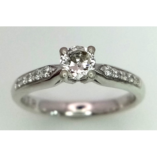 62 - A PLATINUM DIAMOND SOLITAIRE RING WITH A ROUND BRILIANT CENTRE STONE AND DIAMOND SET SHOULDERS, APPR... 