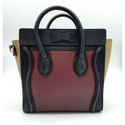 213 - A Celine Burgundy and Khaki Handbag. Crafted from a smooth burgundy leather and features a black lea... 