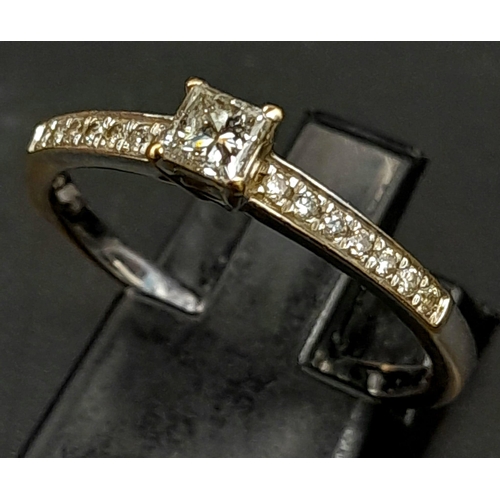 339 - An 18 K yellow and white gold ring with a princess cut diamond  (0.37 carats) and further round cut ... 