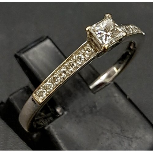 339 - An 18 K yellow and white gold ring with a princess cut diamond  (0.37 carats) and further round cut ... 