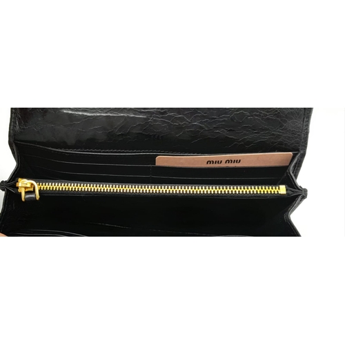 375 - A Miu Miu Black Matelassé Leather Purse/Wallet. Gold logo on the front flap with two press stud clos... 