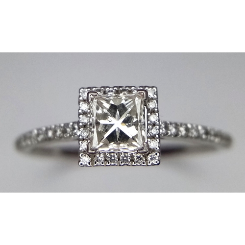 136 - A platinum ring with a princess cut diamond (0.7 carats appr.) and round cut diamonds on the halo an... 