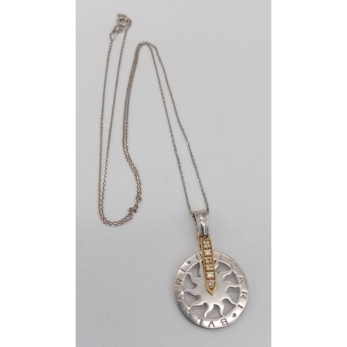 67 - An 18 K white gold chain necklace with a BULGARI 18 K white and yellow gold pendant carrying six rou... 